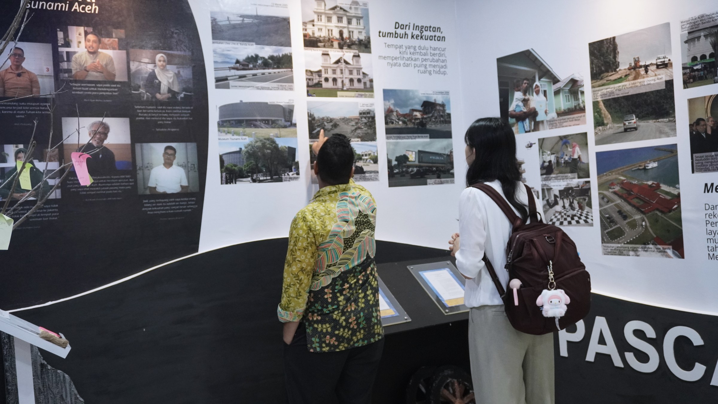Visitors looking at an exhibit about tsunami recovery in Aceh